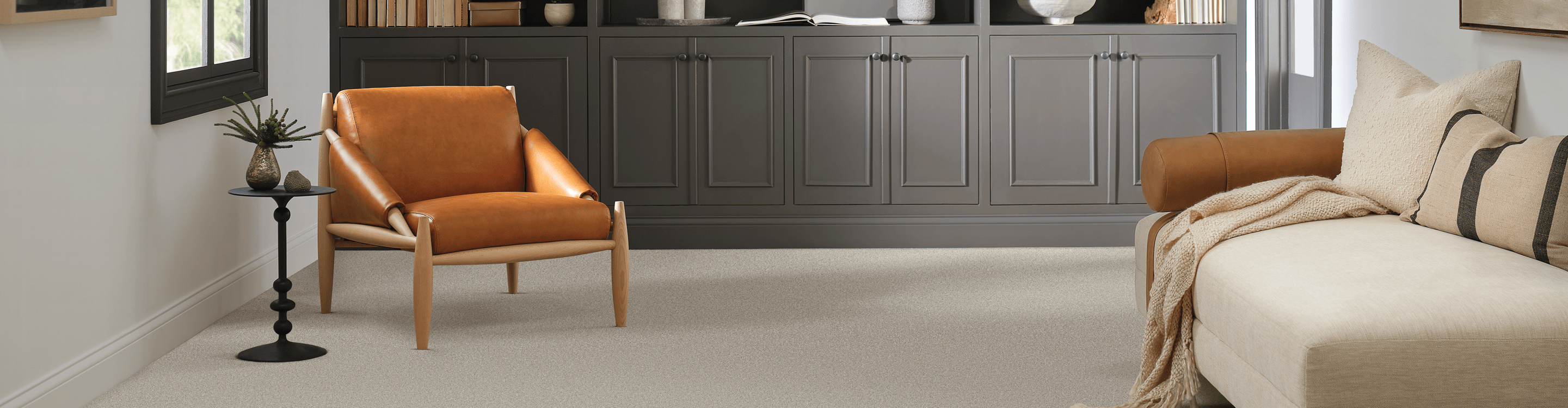 Beige carpet with orange Mid Century Modern chair. 
